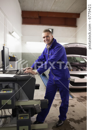Mechanic using a computer while smiling Mechanic using a computer while smiling 6779421
