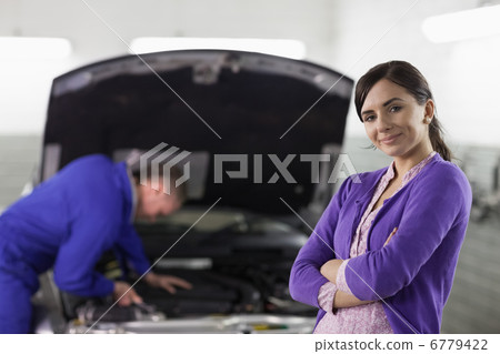 Smiling woman looking at camera next to a car Smiling woman looking at camera next to a car 6779422