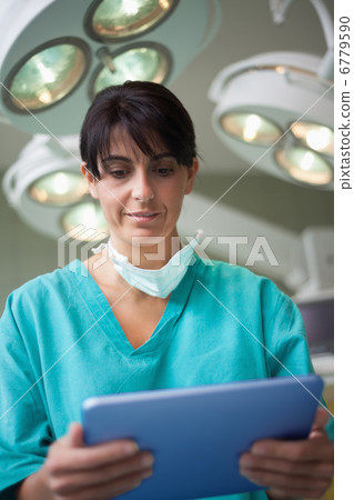 Woman surgeon holding a tactile tablet Woman surgeon holding a tactile tablet 6779590