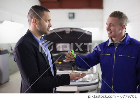 Mechanic giving car key to a man 6779701