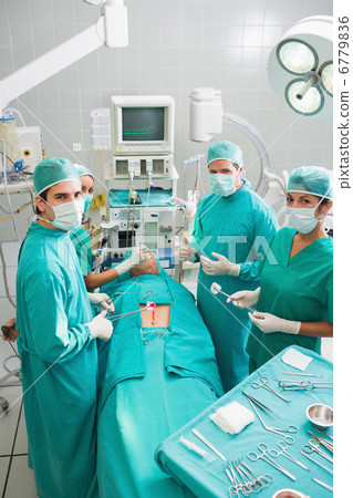 Group of surgeons operating a patient in an operating theater Group of surgeons operating a patient in an operating theater 6779836