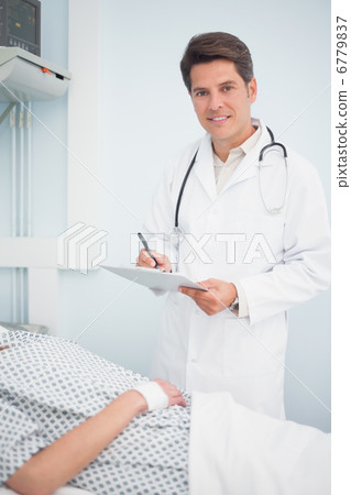 Doctor writing on his chart Doctor writing on his chart 6779837