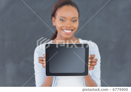 Black woman holding a tablet computer next to a blackboard 6779900