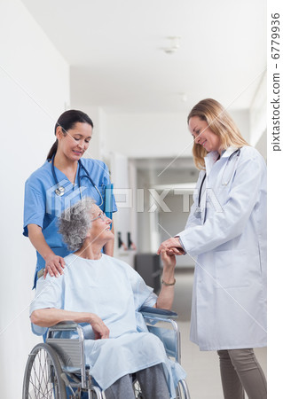 Doctor looking at a patient on a wheelchair 6779936