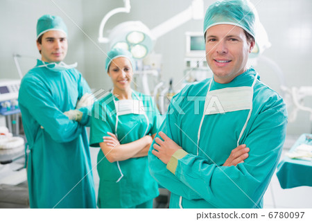Surgical team smiling with arms crossed 6780097