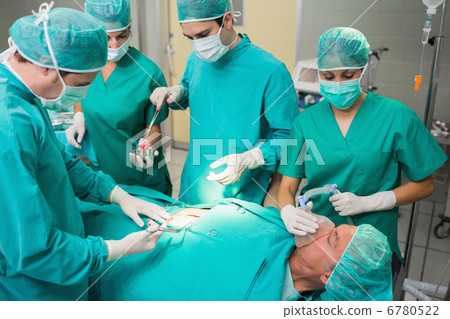 Surgeon giving surgical tool to a nurse 6780522