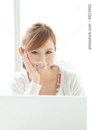 A woman using a personal computer at the window side 6813002
