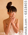 A woman wearing a bath towel 6818403