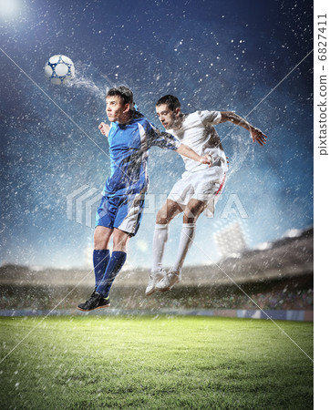 two football players striking the ball two football players striking the ball 6827411