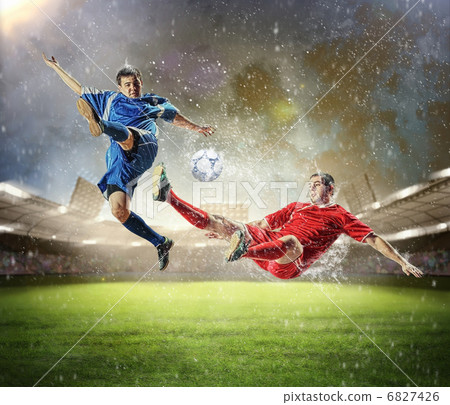 two football players striking the ball two football players striking the ball 6827426