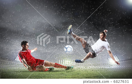 two football players striking the ball two football players striking the ball 6827631