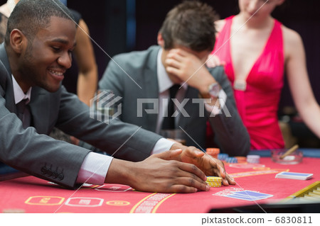 Man winning jackpot as other man is being comforted by woman 6830811