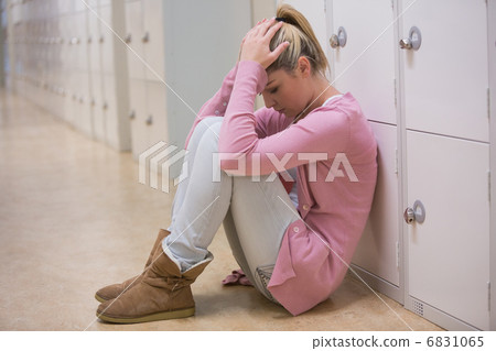 Upset student sitting on floor of hallway Upset student sitting on floor of hallway 6831065