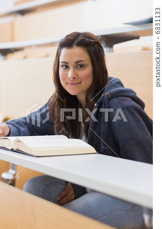 Woman sitting at the lecture hall reading 6831133