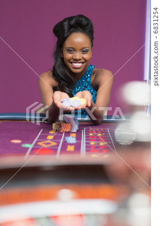 Woman smiling holding up chips Woman smiling holding up chips 6831254