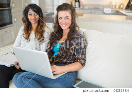 Happy girls using laptop for homework 6831284