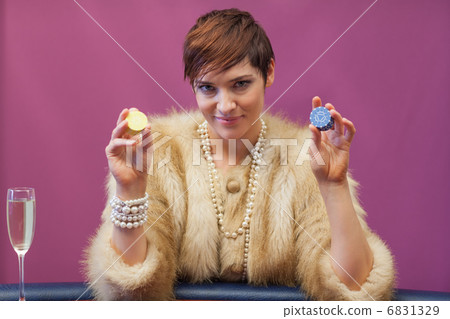 Woman in a casino holding chips Woman in a casino holding chips 6831329