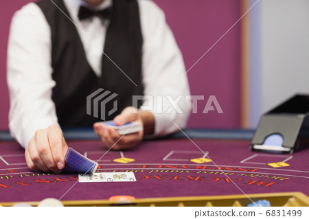 Dealer dealing cards in a casino 6831499