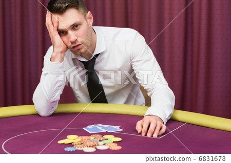 Man looking worried at poker table 6831678
