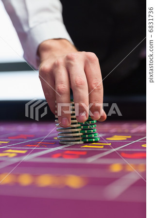 Dealer placing chips on table 6831736