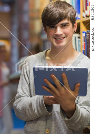 Man with tablet pc beside bookshelf Man with tablet pc beside bookshelf 6831805