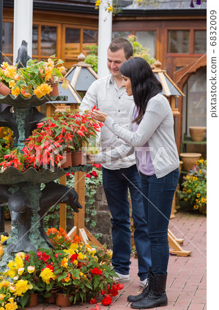 Couple looking at red plant 6832009