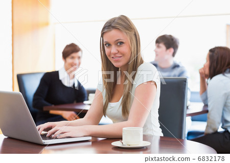 Woman sitting at the coffee shop at table using laptop Woman sitting at the coffee shop at table using laptop 6832178