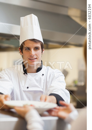 Chef passing plate to waitress Chef passing plate to waitress 6832194