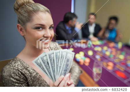 Blonde woman holding fan of dollars Blonde woman holding fan of dollars 6832420