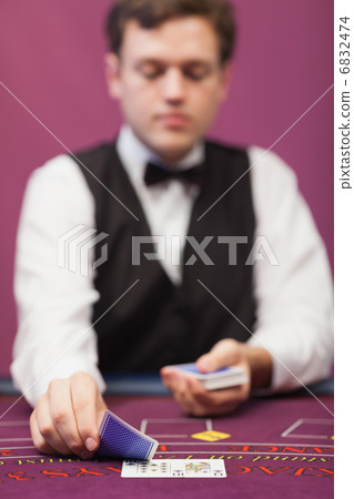 Dealer in a casino distributing cards 6832474