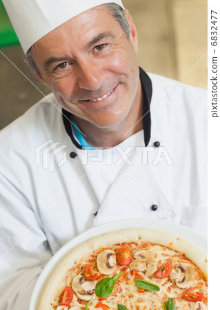 Smiling chef holding a pizza 6832477