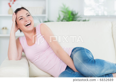 Laughing woman relaxing on the couch Laughing woman relaxing on the couch 6832689