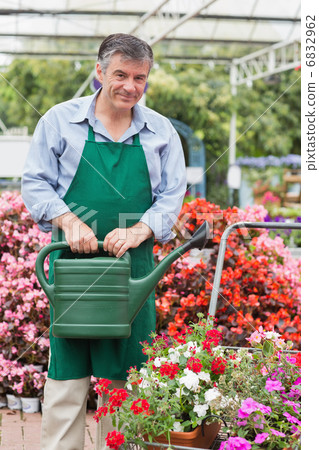 Man holding a watering can 6832962