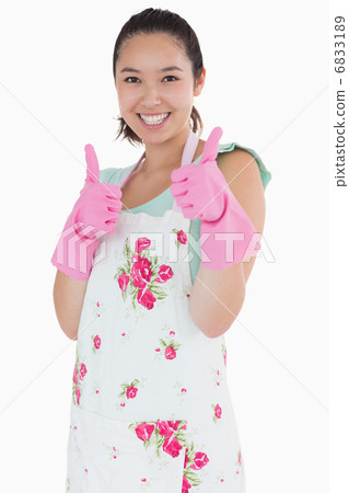 Woman wearing rubber gloves giving thumbs up 6833189