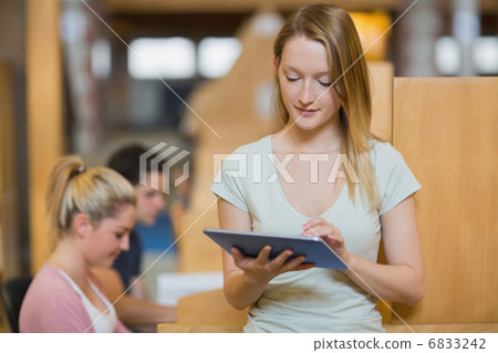 Woman standing holding a tablet pc at the library 6833242