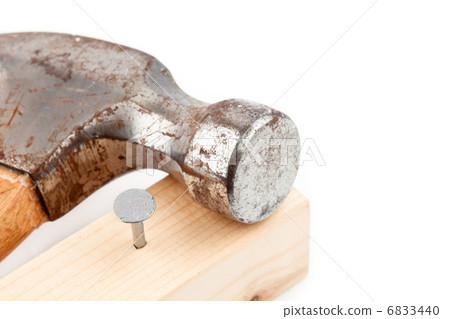 Nail sticking in a plank with a hammer 6833440