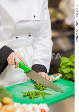 Chef slicing up scallions 6833482