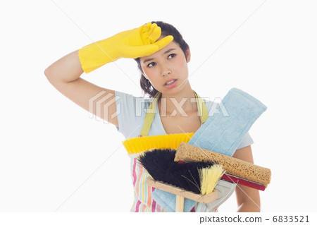 Weary woman holding cleaning tools 6833521
