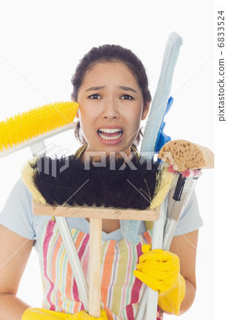 Distressed woman holding cleaning tools 6833524