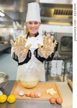 Baker showing her hands with dough 6833640