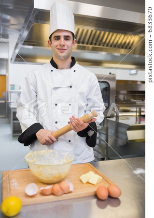 Pastry chef holding rolling pin 6833670