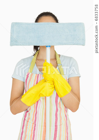 Young woman hiding behind mop 6833758