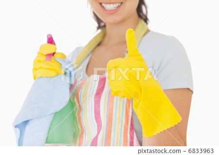 Woman giving thumbs up holding cleaning products 6833963