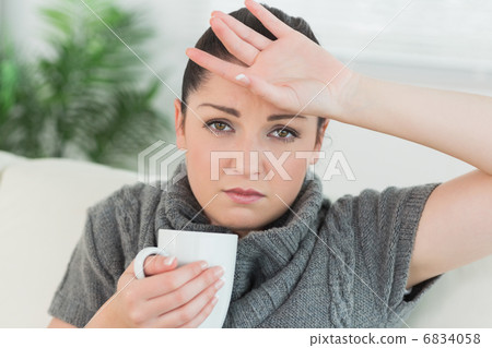 Ill woman sitting on the couch in a living room 6834058