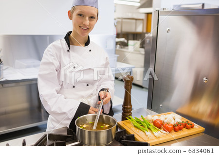 Smiling chef stirring soup 6834061