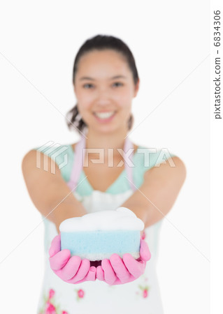 Woman holding a cleaning sponge 6834306
