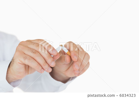 Male hands breaking a cigarette 6834323