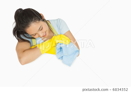 Smiling woman in rubber gloves looking at white surface 6834352