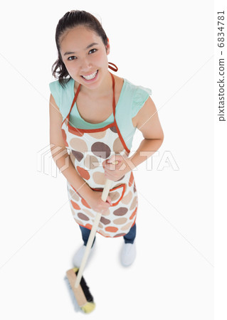 Smiling woman sweeping the floor 6834781
