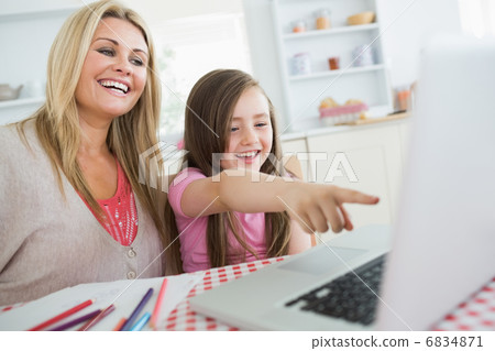 Little girl and mother laughing at laptop 6834871